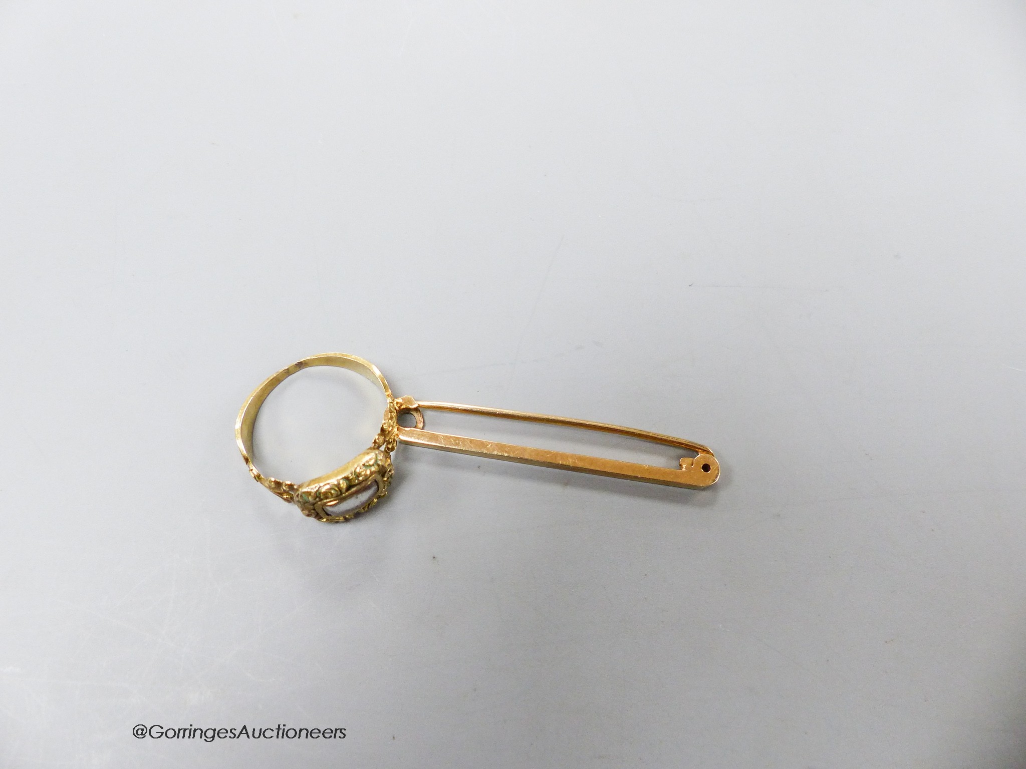 A 19th century yellow metal remembrance ring with glazed hair panel, size P/Q and a 9ct gold tie pin, gross weight 5.6 grams.